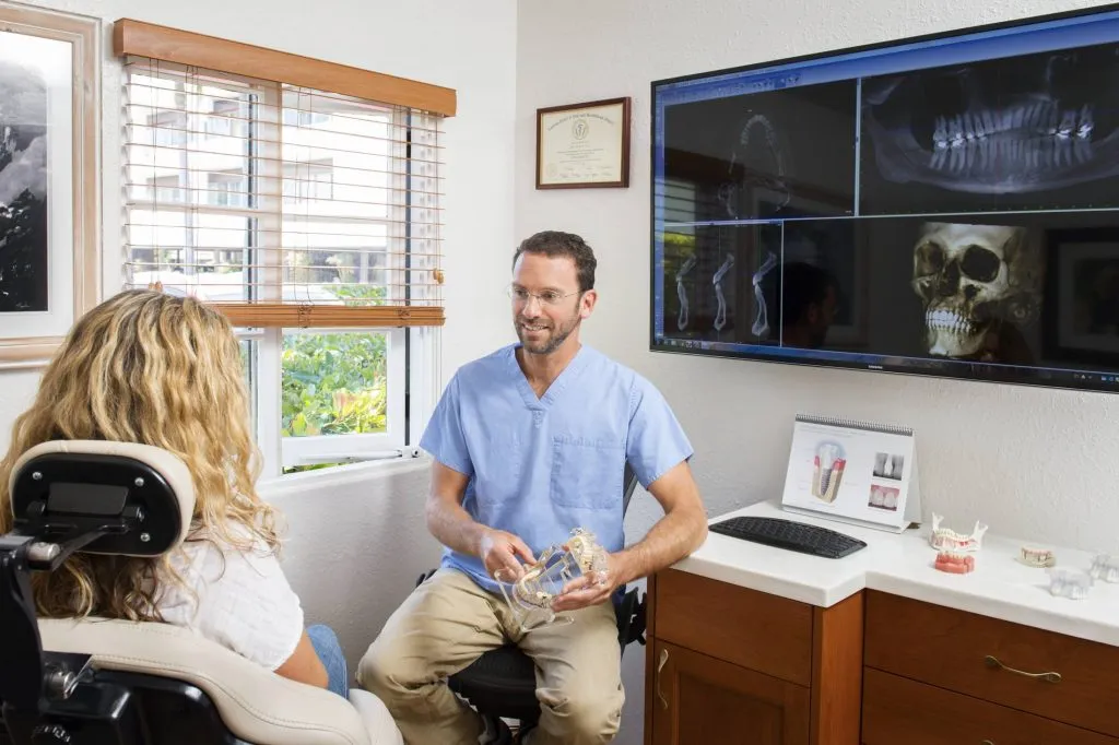 [LAST_NAME] speaking with a patient at Shoreline Oral Surgery & Dental Implants